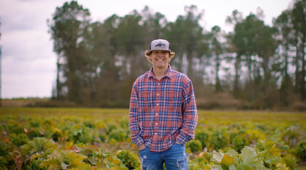 Agriculture student smiling in a corn field